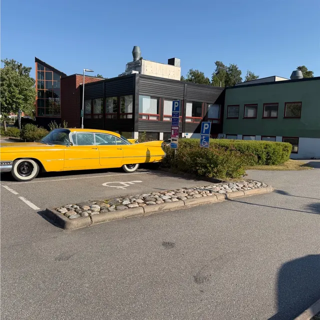 Gul veteranbil parkerad utanför klubblokalen